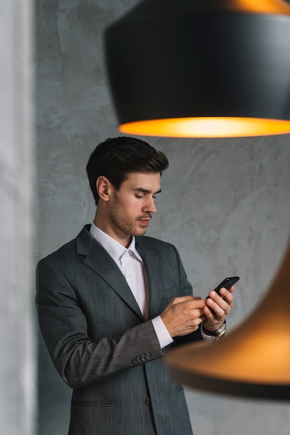 Joven, hombre de negocios, en, trajes, utilizar, teléfono celular