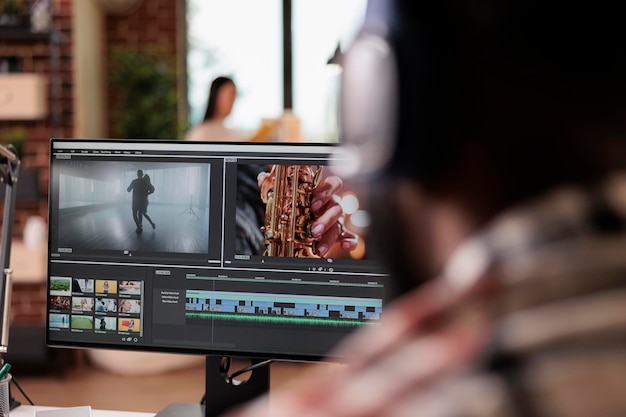 Joven independiente editando metraje en software, trabajando para editar montajes de video con gradación de color y efectos de audio. Contenido de producción de sonido y cine, haciendo películas creativas en la computadora.