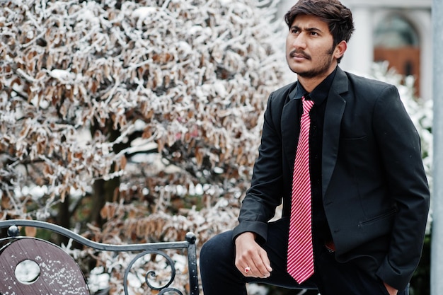 Foto gratuita joven indio con traje y corbata posó al aire libre en un día de invierno