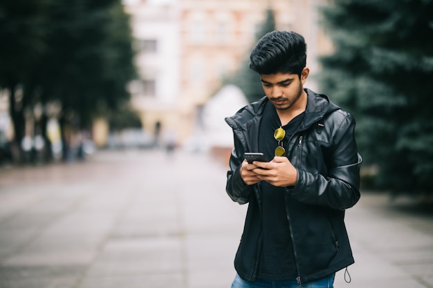 Foto gratuita joven indio vestido con ropa de moda para monitorear la información de las redes sociales