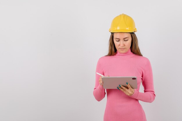 La joven ingeniera está trabajando en una tableta con fondo blanco