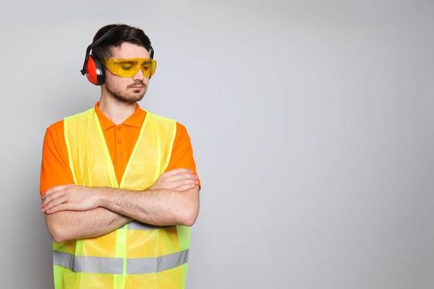 Joven ingeniero civil en protectores auditivos y gafas