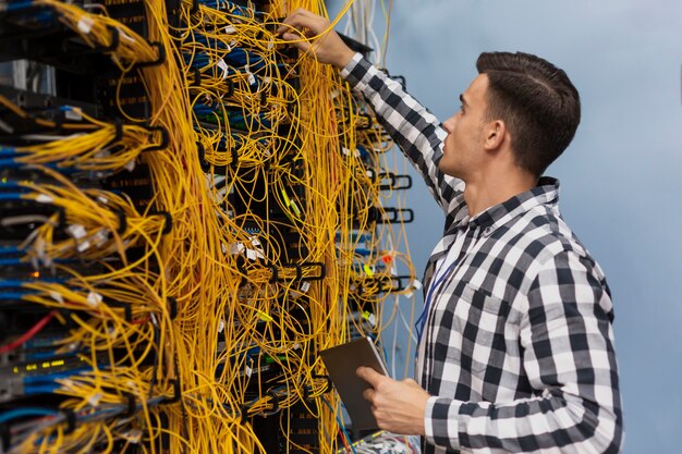 Joven ingeniero de redes trabajando en una sala de servidores