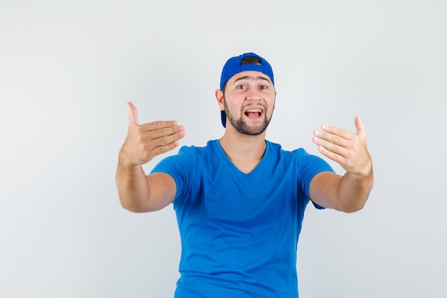 Joven invitando a venir en camiseta azul y gorra