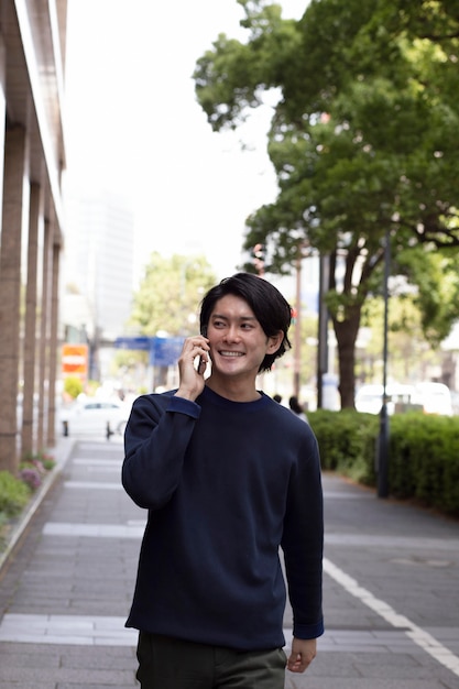 Joven japonés en un suéter azul al aire libre