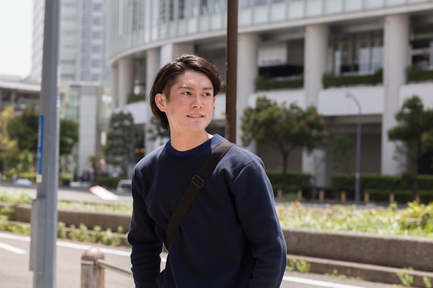 Joven japonés en un suéter azul al aire libre
