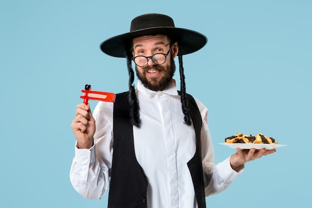 El joven judío ortodoxo con galletas hamantaschen para el festival Purim. Vacaciones, celebración, judaísmo, pastelería, tradición, galleta, concepto de religión