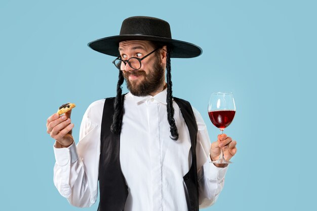 El joven judío ortodoxo con sombrero negro con galletas Hamantaschen para la fiesta judía de Purim