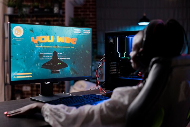 Foto gratuito joven jugador celebrando la exitosa victoria de los videojuegos en línea, usando la computadora para transmitir el juego. mujer moderna ganando el juego de campeonato de tiro de acción, divirtiéndose con la competencia.