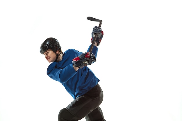 Foto gratuita joven jugador de hockey con el palo en la cancha de hielo y pared blanca