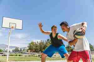 Foto gratuita joven jugador masculino jugando con el jugador de baloncesto