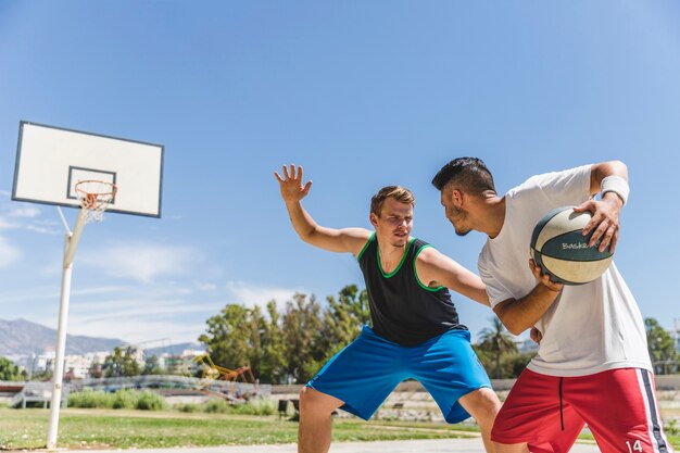 Joven jugador masculino jugando con el jugador de baloncesto