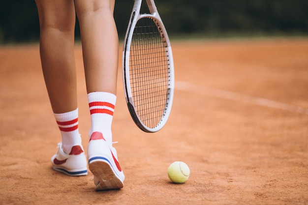 Joven jugadora de tenis en la cancha, pies de cerca