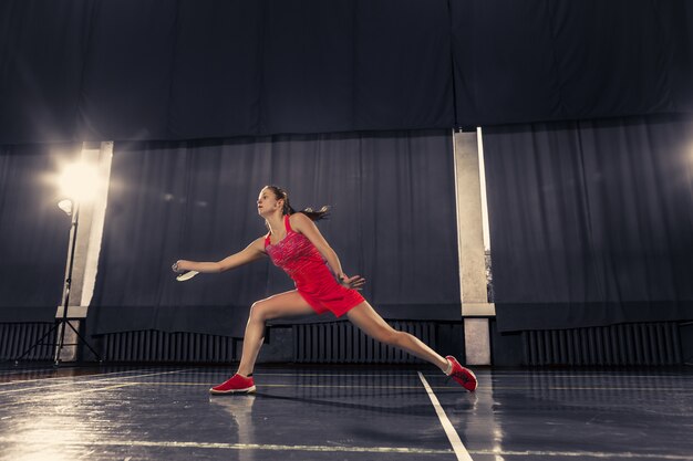 Joven jugando bádminton en el espacio del gimnasio