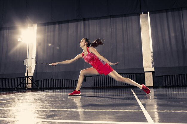 Joven jugando bádminton en el gimnasio