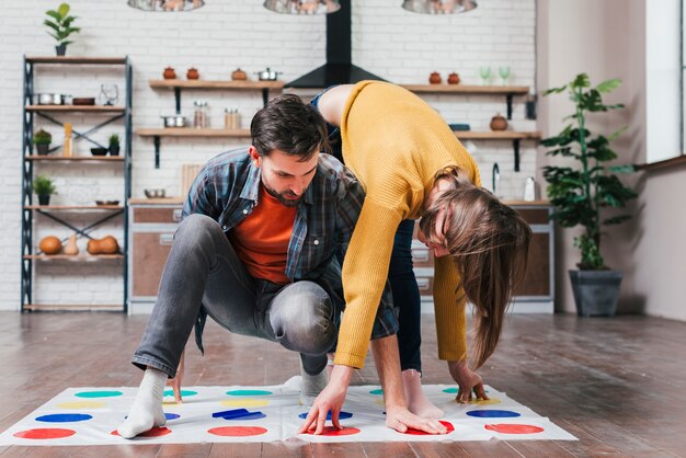 Joven jugando twister juego con su esposa en casa