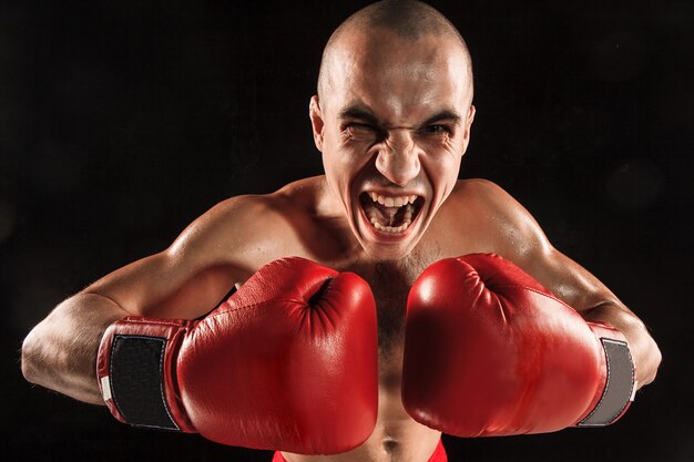 El joven kickboxing en negro con cara de gritos