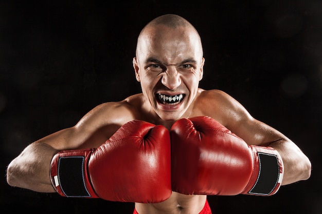 joven kickboxing en negro con protección en la boca