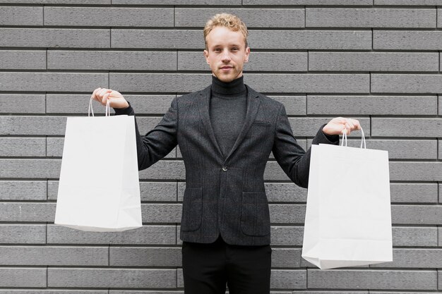 Joven levantando las bolsas de compras