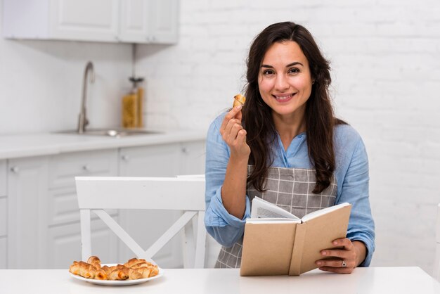 Joven leyendo un libro en la cocina