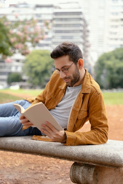 Foto gratuita joven leyendo un libro interesante