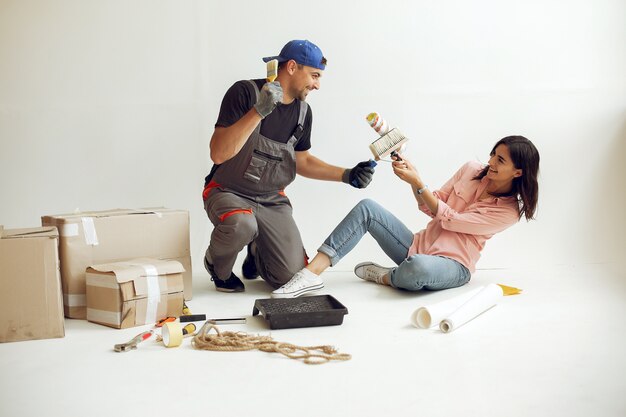 La joven y linda familia repara la habitación.