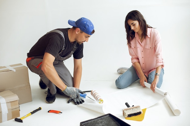 La joven y linda familia repara la habitación.