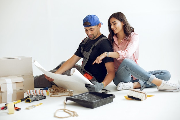 La joven y linda familia repara la habitación.