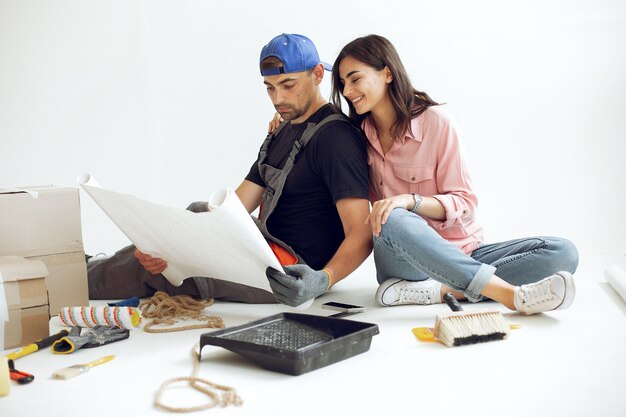 La joven y linda familia repara la habitación.