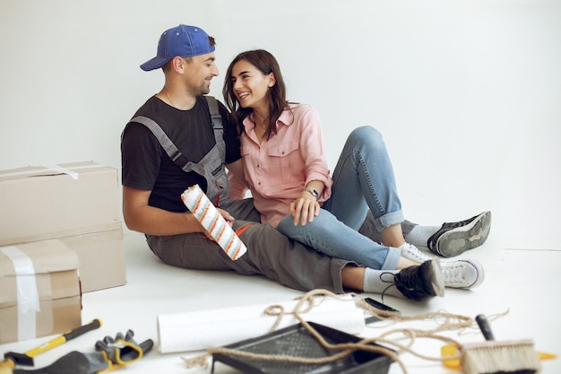 La joven y linda familia repara la habitación.