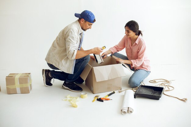 La joven y linda familia repara la habitación.