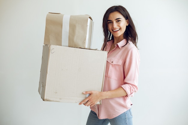 La joven y linda mujer repara la habitación.