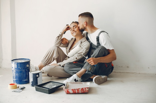 La joven y linda pareja repara la habitación