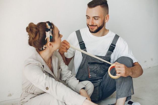 La joven y linda pareja repara la habitación