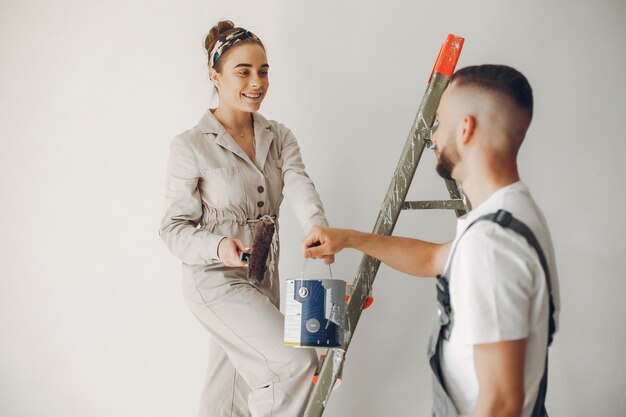 La joven y linda pareja repara la habitación