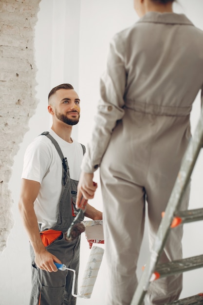 La joven y linda pareja repara la habitación