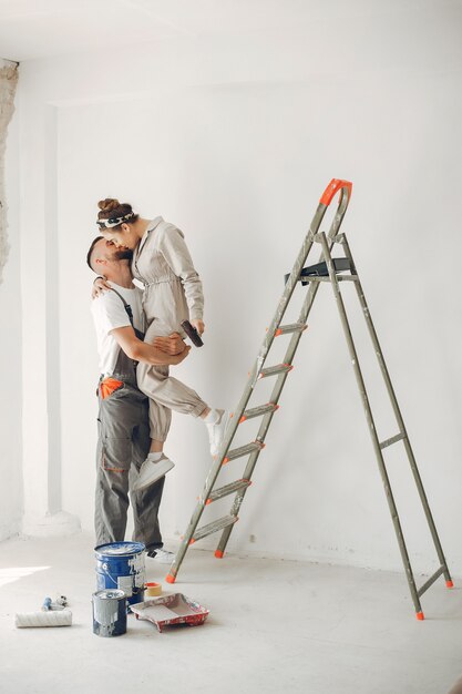 La joven y linda pareja repara la habitación