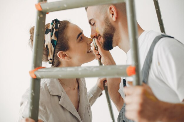 La joven y linda pareja repara la habitación