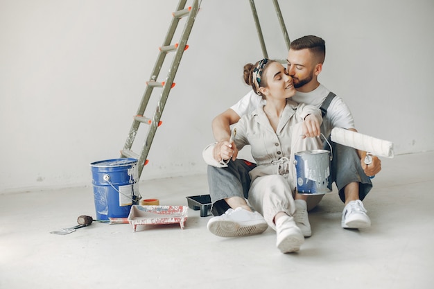 La joven y linda pareja repara la habitación