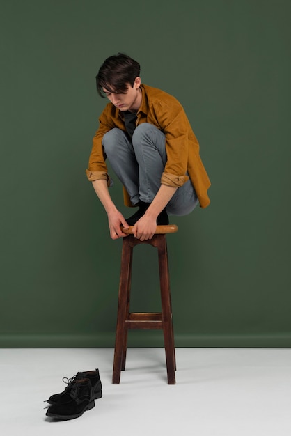 Joven, llevando, camisa, posar, en, silla