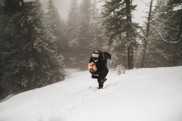 Joven llevando leña en invierno