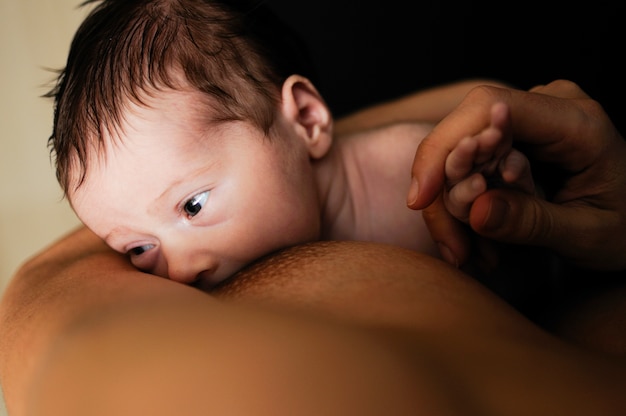 Foto gratuita joven madre amamantando recién nacido en casa