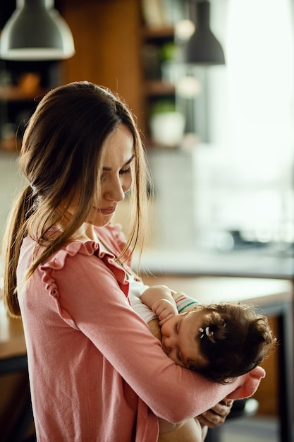 Foto gratuita joven madre amorosa disfrutando mientras amamanta a su hija en casa