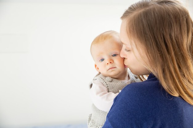 Joven madre besando lindo niño infantil