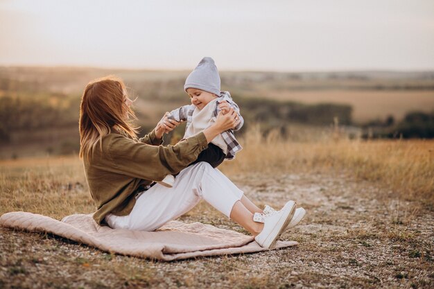 Joven madre divirtiéndose con su pequeño hijo