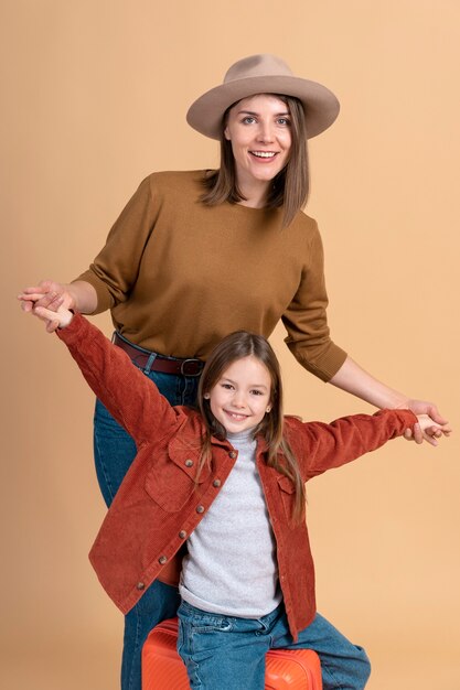 Joven madre e hija posando juntas antes de viajar de vacaciones