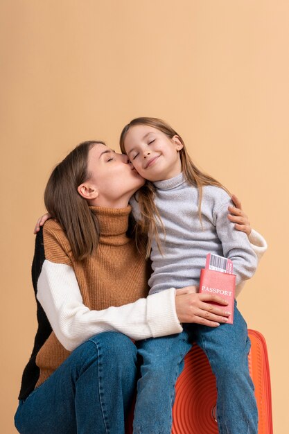 Joven madre e hija posando juntas antes de viajar de vacaciones