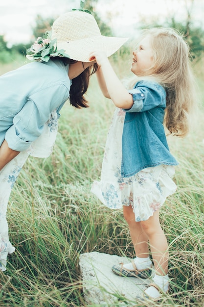 La joven madre e hija sobre la hierba verde