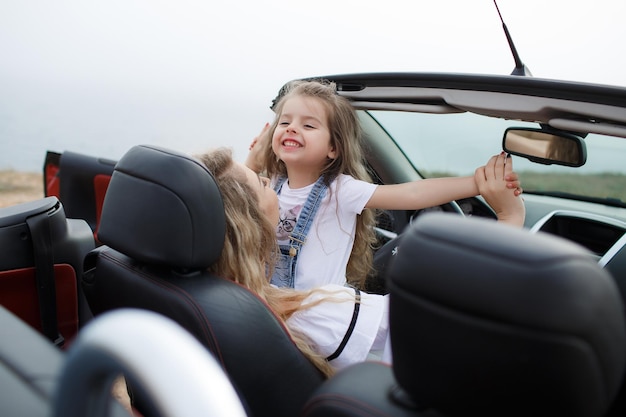 joven madre e hija en vacaciones en coche