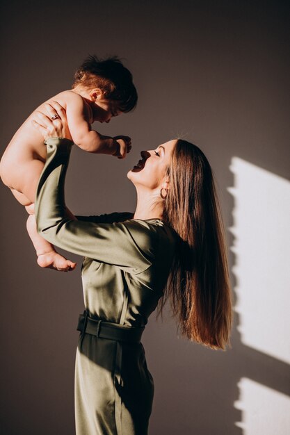 Joven madre hermosa con su hijo pequeño, practicando la lactancia materna